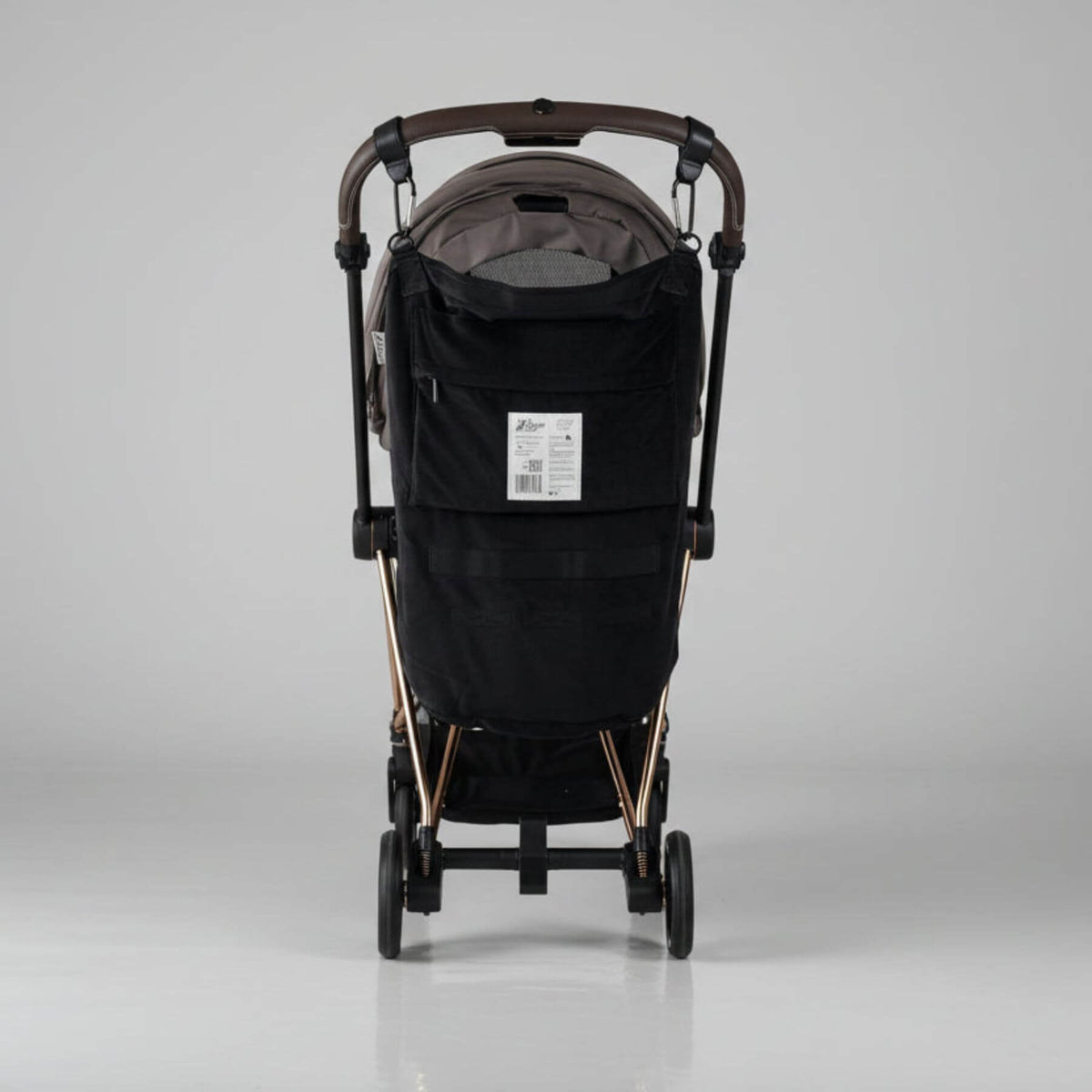 Black stroller with The Stroller Sling - All Weather on a gray background