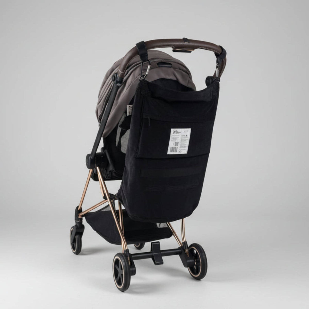 Black stroller with The Stroller Sling - All Weather on a light gray background