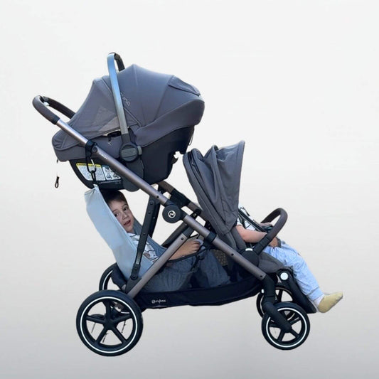 Double stroller and The Stroller Sling Attached, with two children sitting inside on a light gray background
