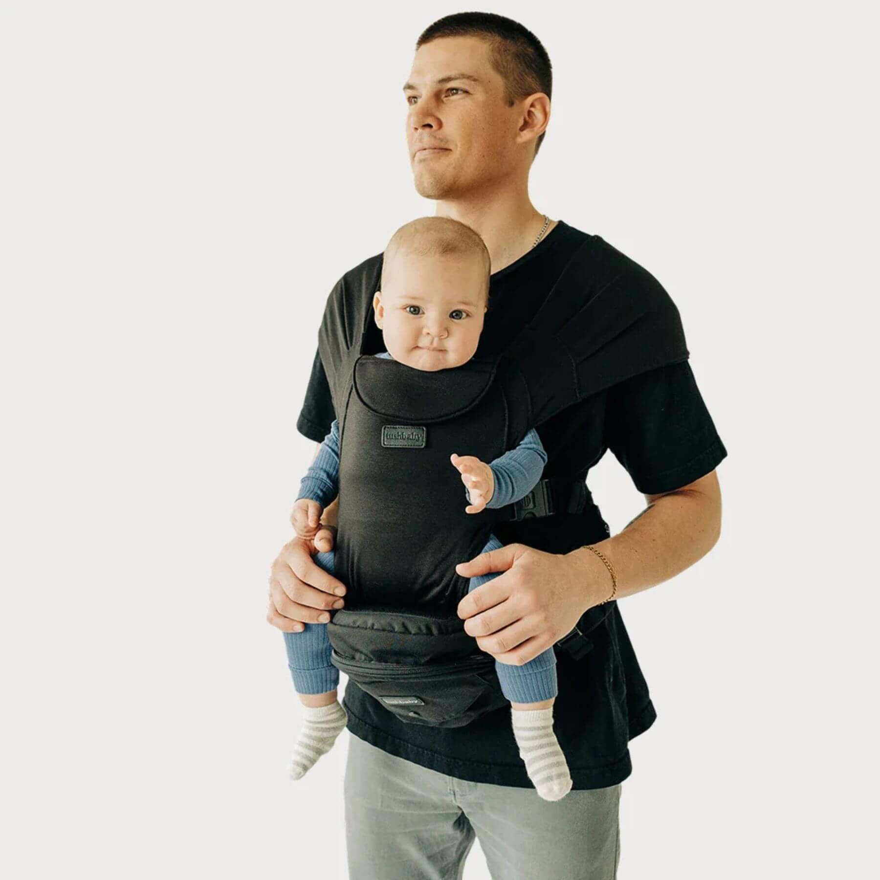 Man holding a baby in The Tushbaby Hip Carrier - Black