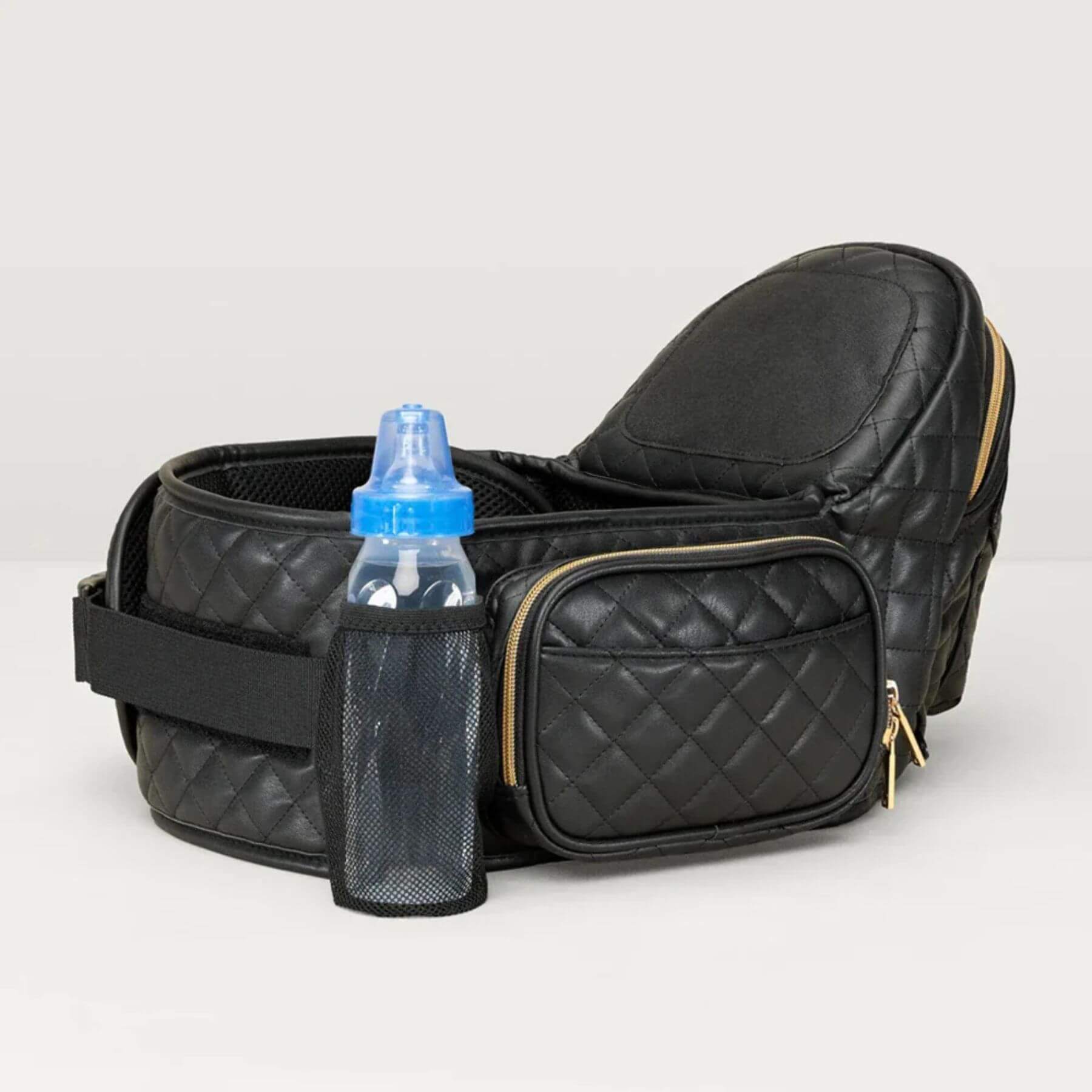 The Tushbaby Hip Carrier - Black/Gold with a blue bottle