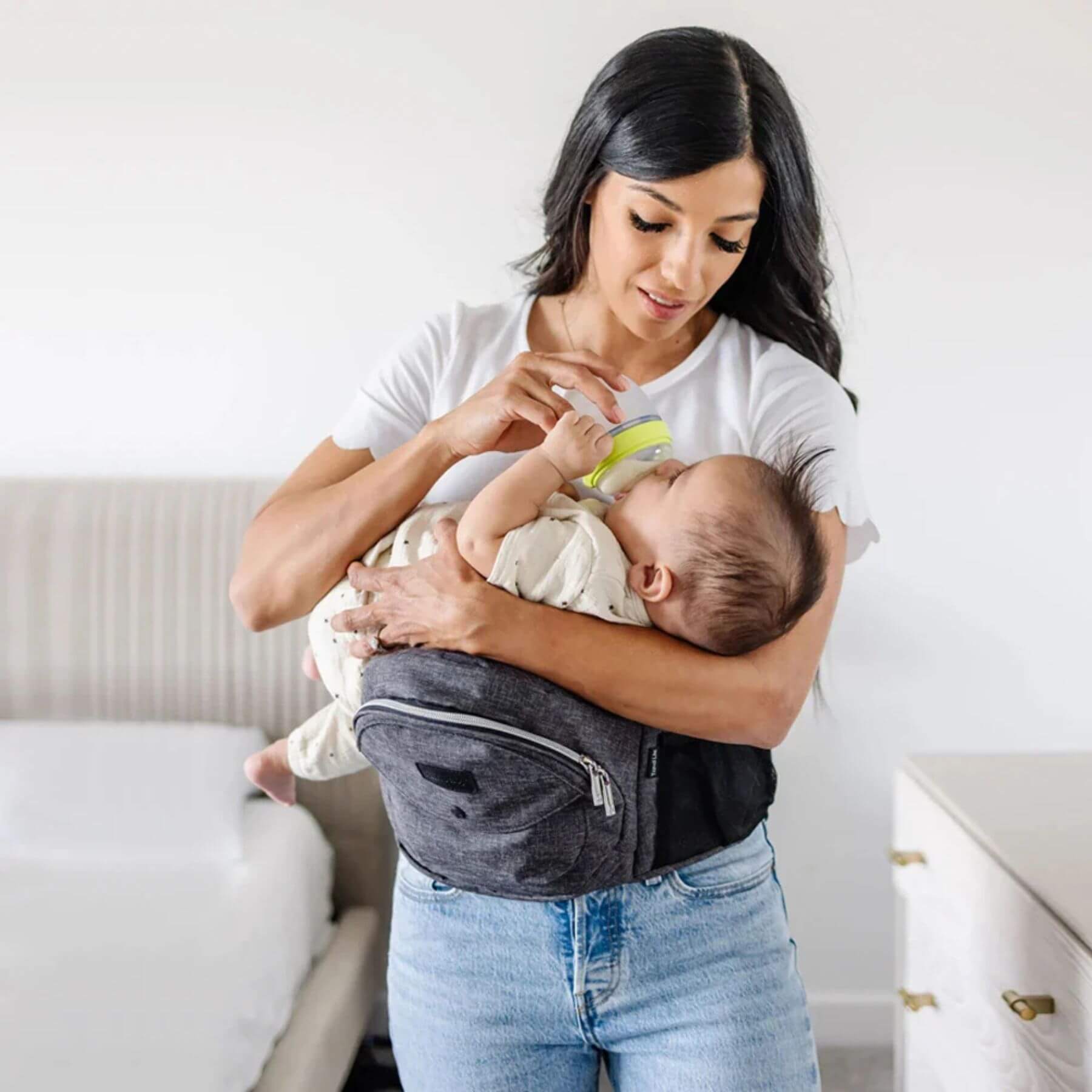 Woman holding a baby in The Tushbaby Hip Carrier - Orchid