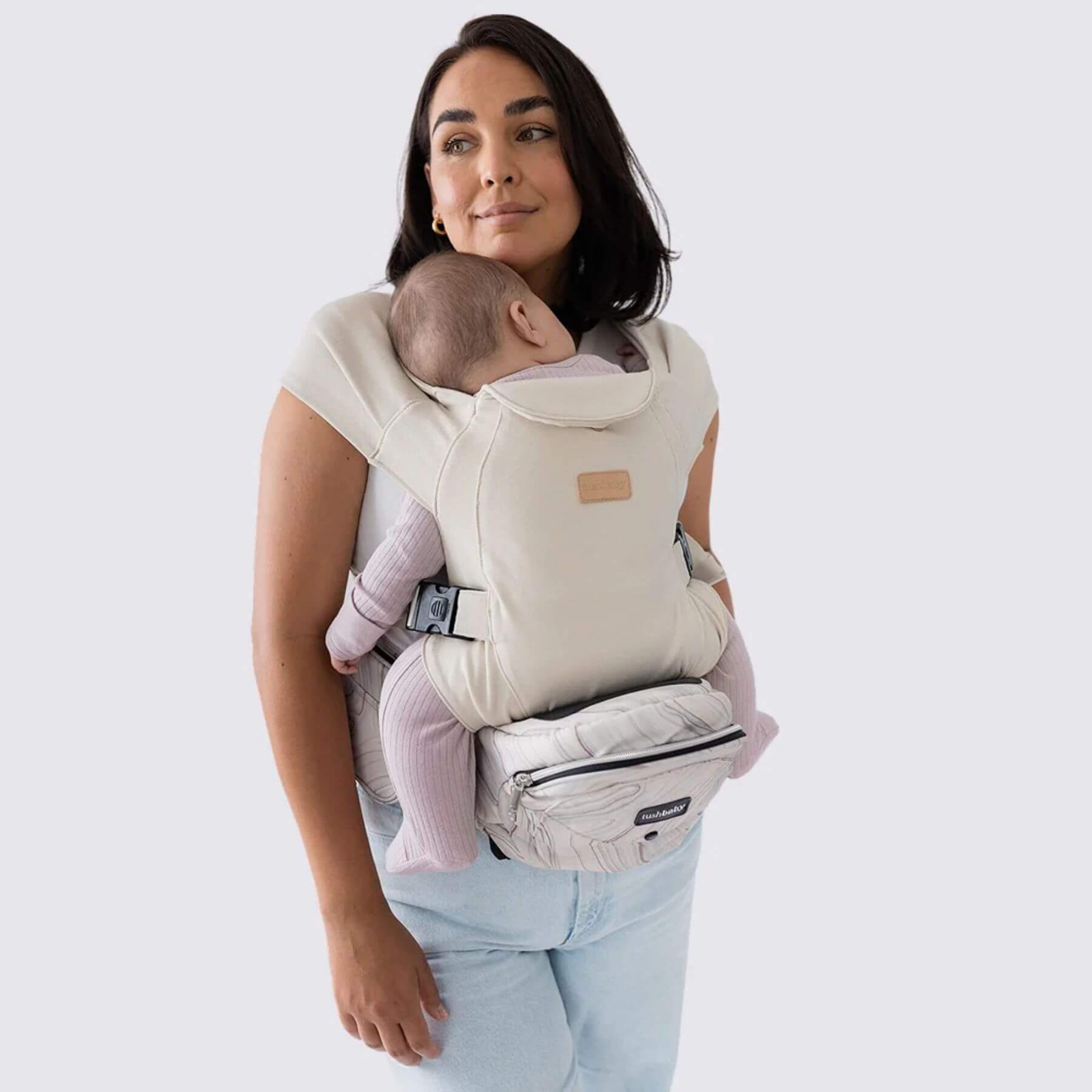 Woman holding a baby in The Tushbaby Hip Carrier - Marbel