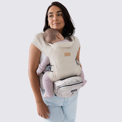 Woman holding a baby in The Tushbaby Hip Carrier - Marbel