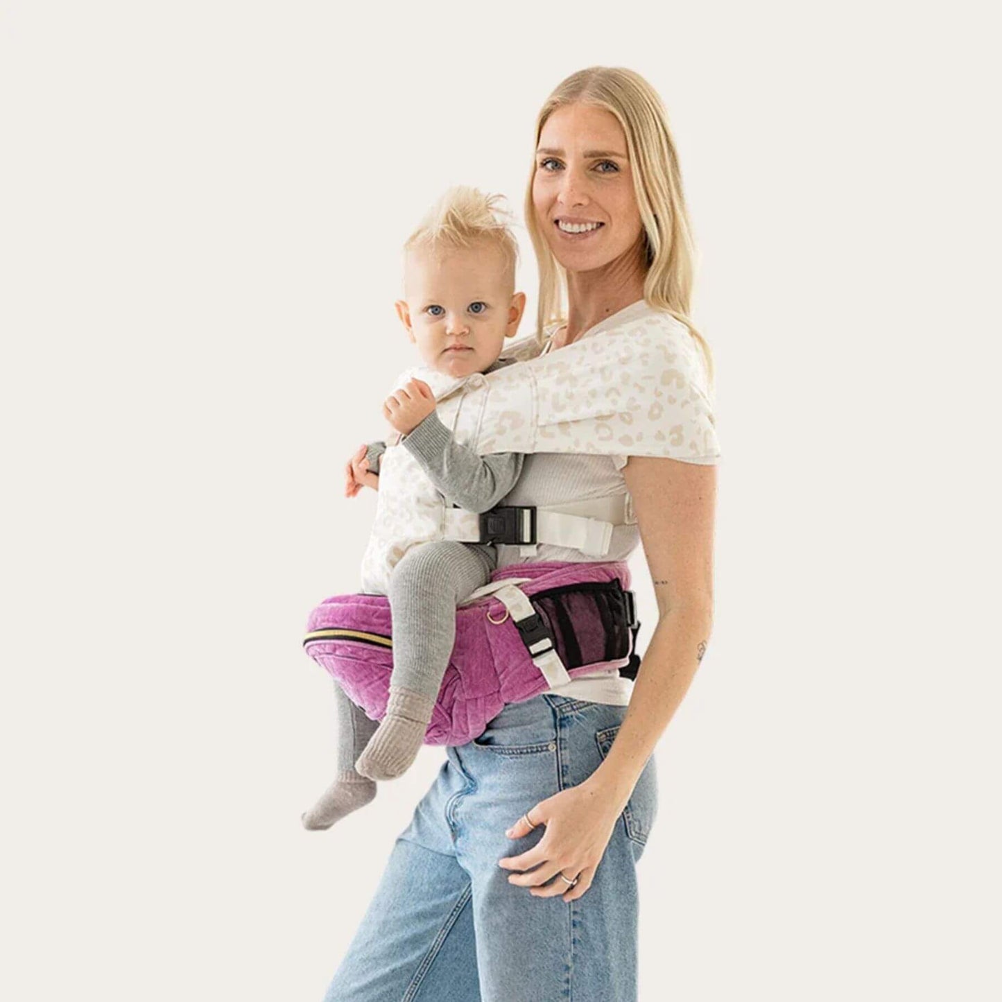 Woman holding a baby in The Tushbaby Hip Carrier - Orchid