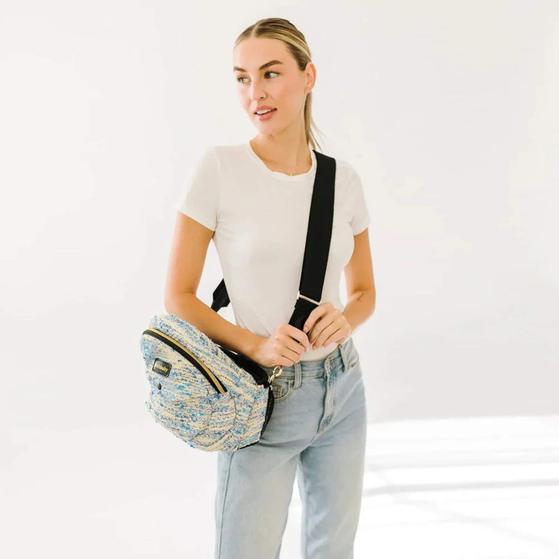 Woman holding a patterned bag against a white background