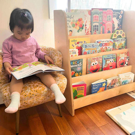 Girl Reading next to RAD Children's Furniture Tiered Montessori Bookshelf