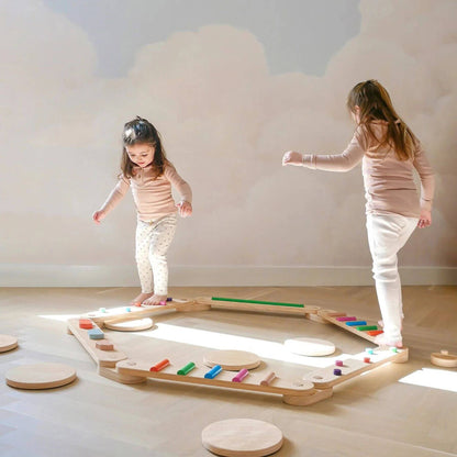Two children playing with Tiny Land® Balance Beam indoors.