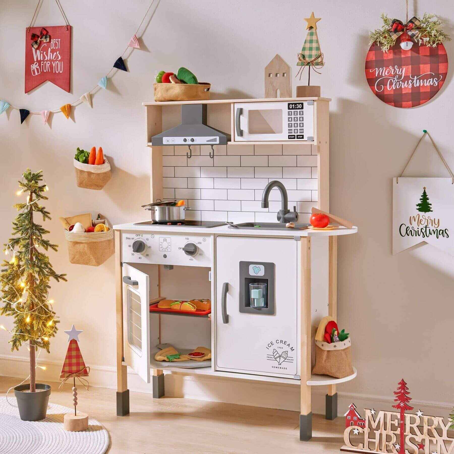 Tiny Land® Interactive Play Kitchen with Sounds & Cookware with Christmas decorations in a room.