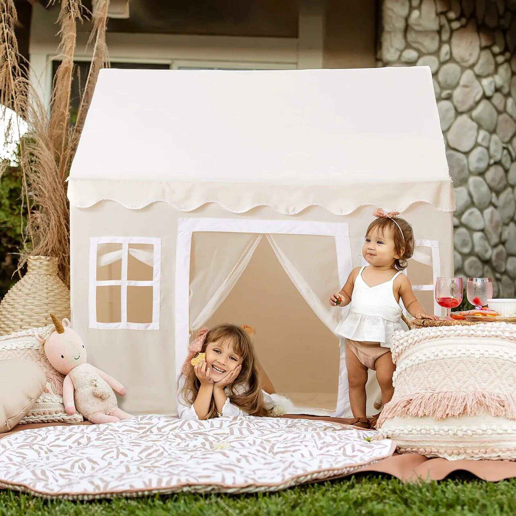 Two children playing inside Tiny Land® Playhouse Tent – Natural Cream in an outdoor setting.