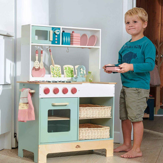 Child playing with Tender Leaf Kitchen Range in a room.