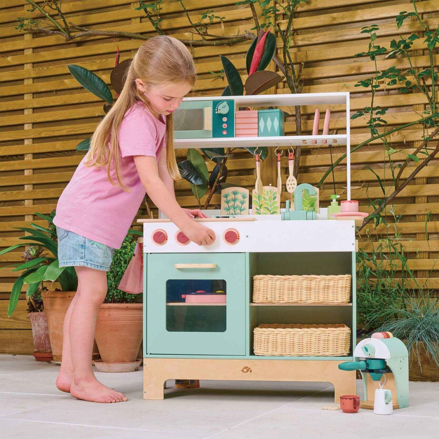 Child playing with Tender Leaf Kitchen Range outdoors