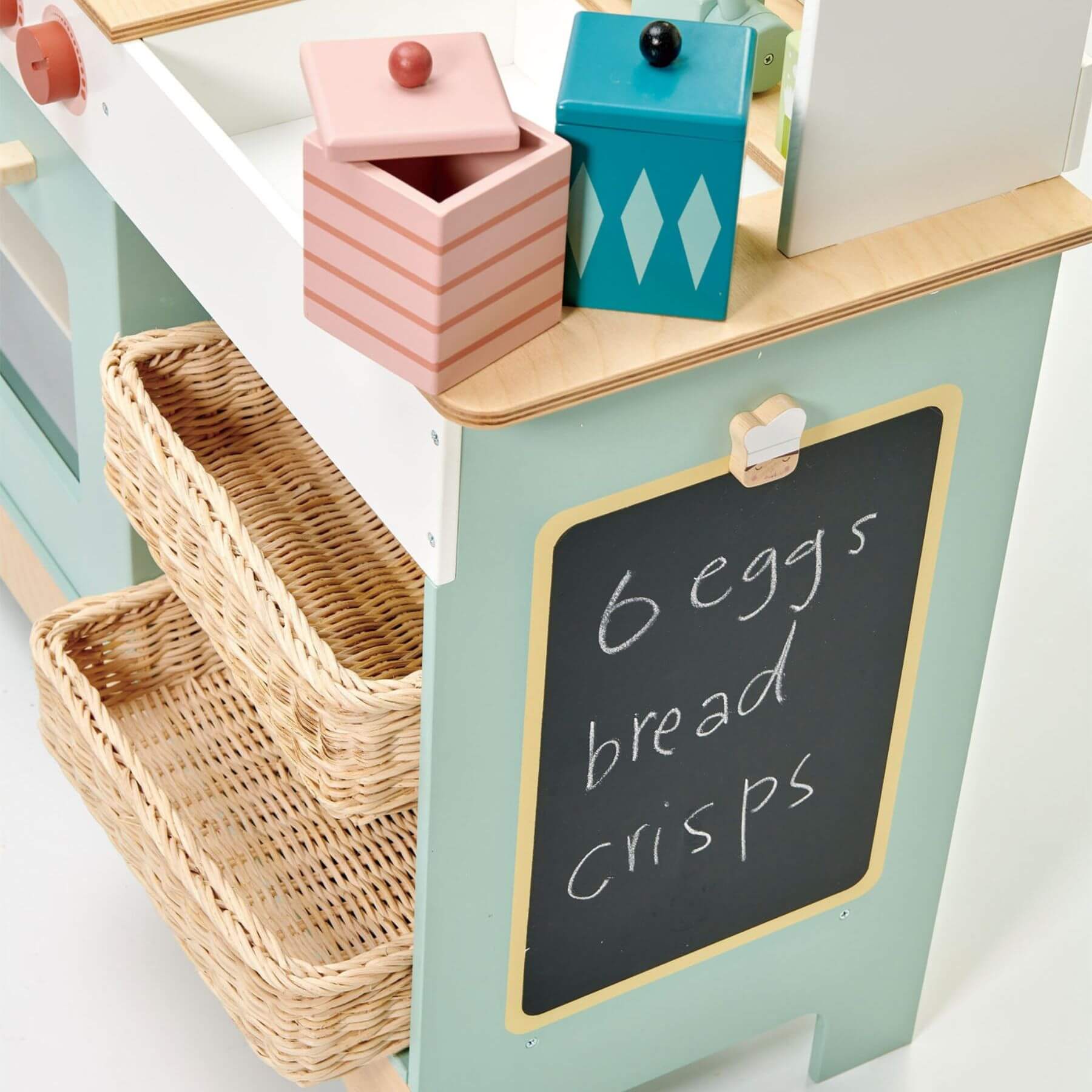 Children's play kitchen with wicker basket, colorful toy boxes, and a chalkboard sign.