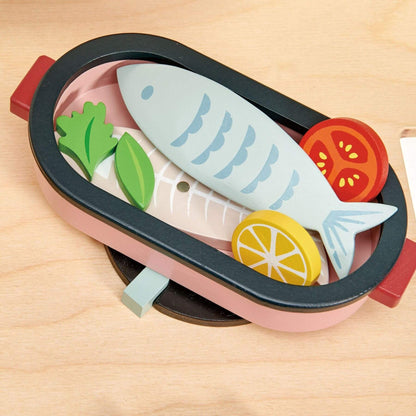 Toy sushi set with fish, vegetables, and lemon on a wooden surface