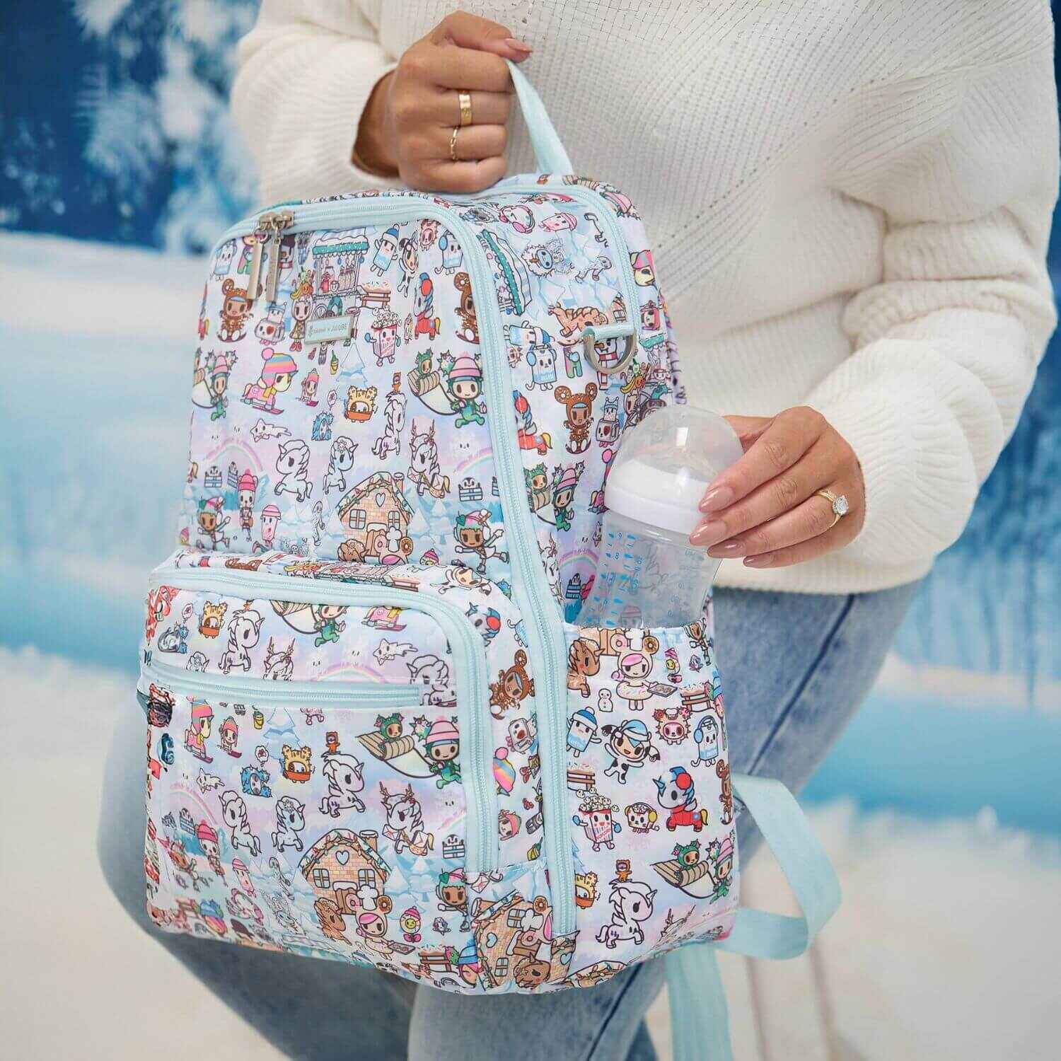 Woman Putting Bottle in tokidoki Snow Day Zealous Backpack Diaper Bag — Ice Blue