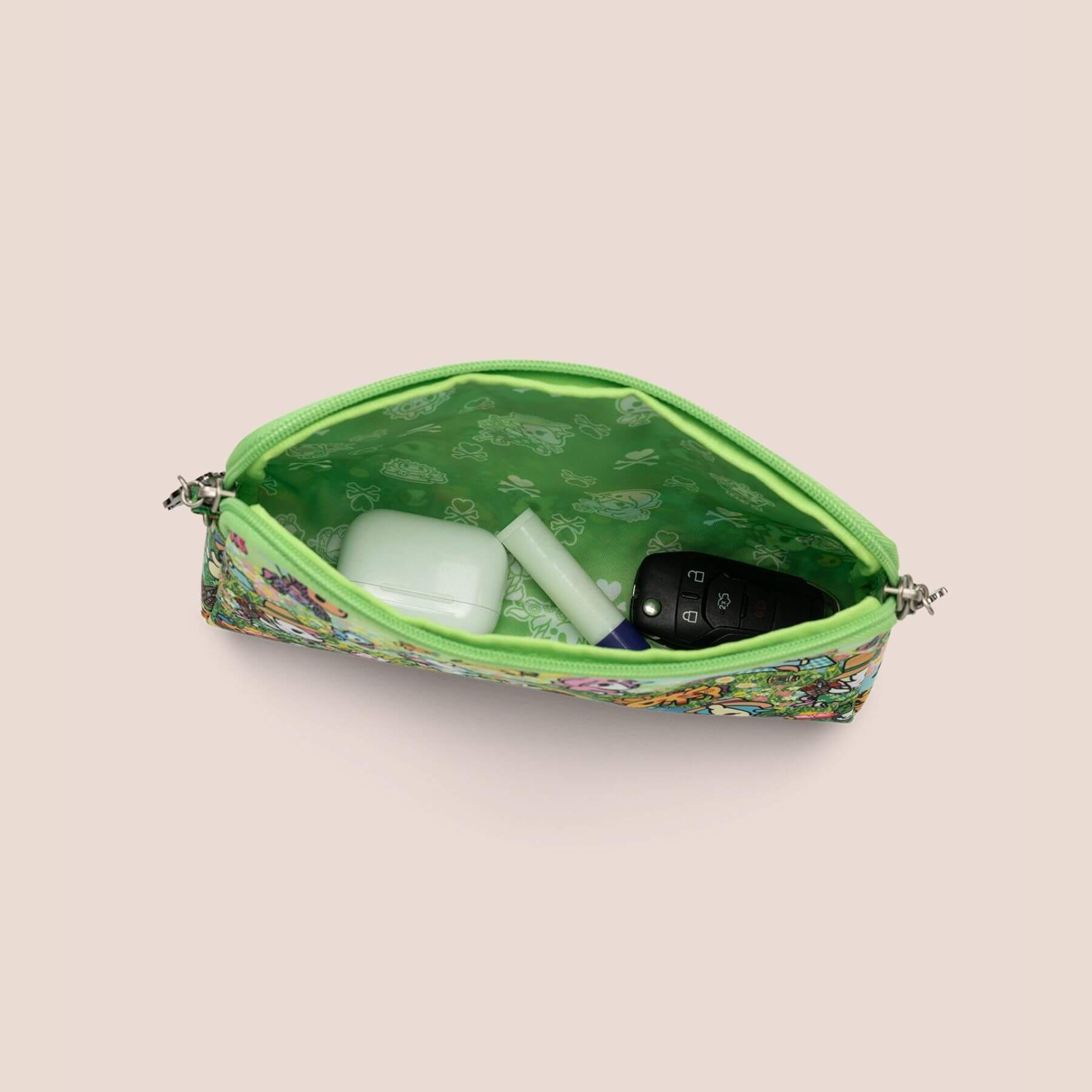 Green patterned pouch with items inside on a beige background