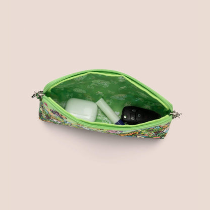 Green patterned pouch with items inside on a beige background