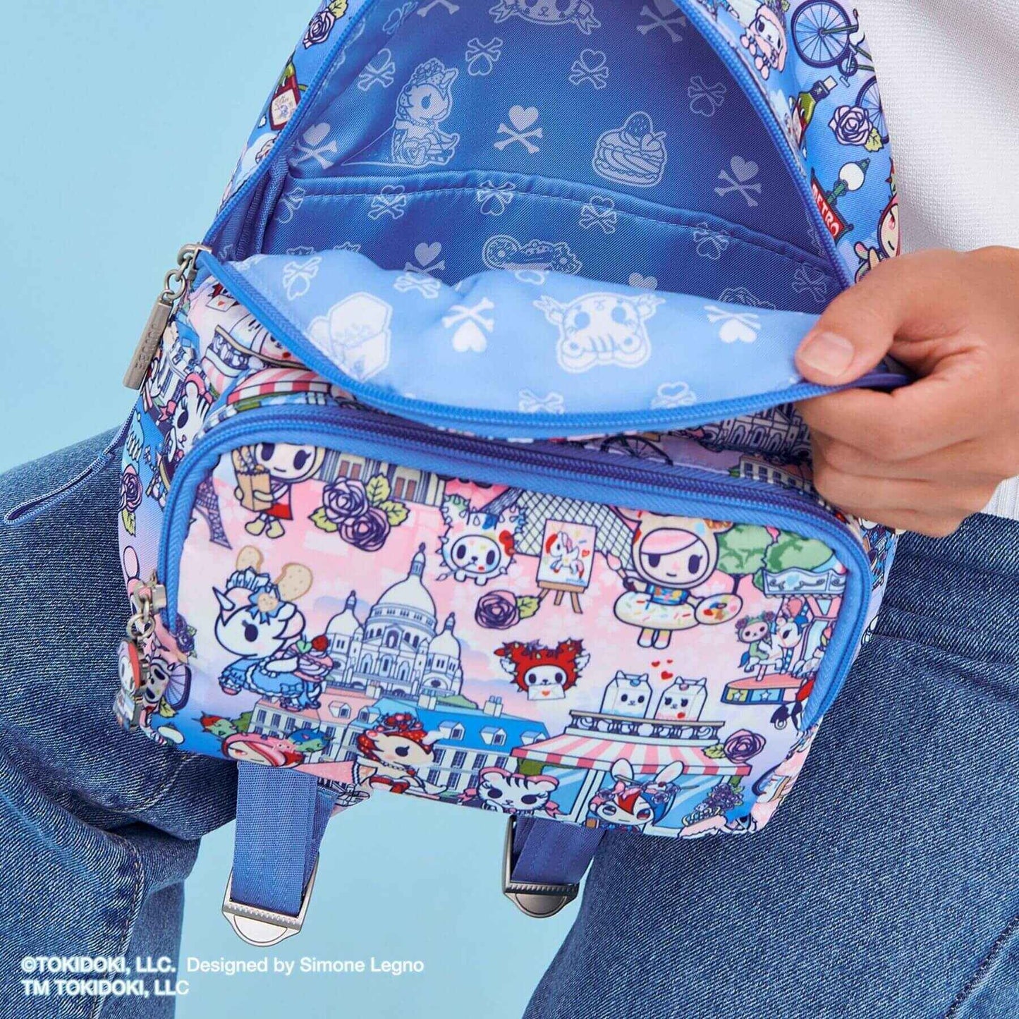 tokidoki Everyday Mini Backpack - C'est la vie à Paris held by a person against a light blue background