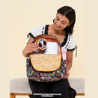 A woman wearing a white and black top holds a colorful Kuromi-patterned backpack with tokidoki Sugar Skull Mini Bag Clip-On Pouch Accessory – Dia de los Muertos
