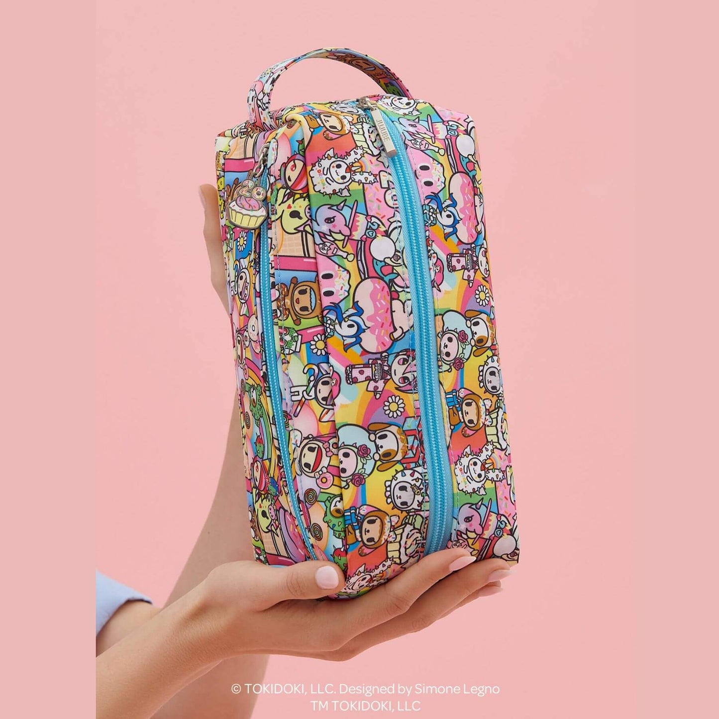 tokidoki Be Dapper Toiletry Cosmetic Pouch - 20th Anniversary Celebration held by a hand on a pink background