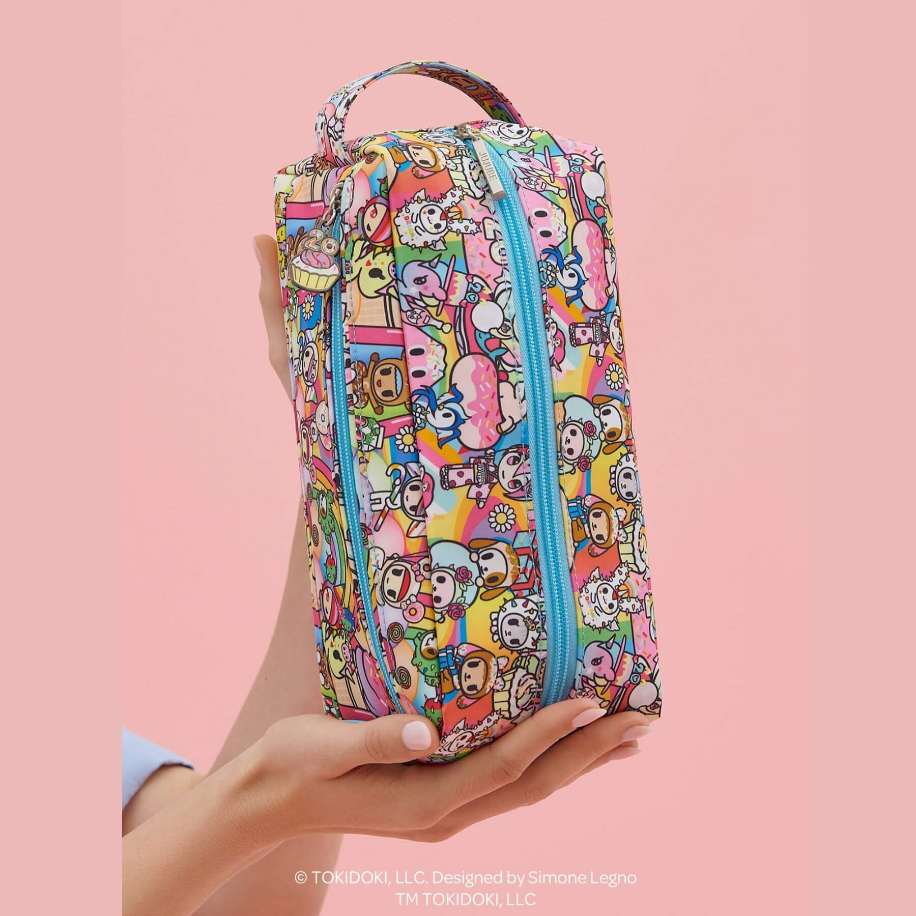 tokidoki Be Dapper Toiletry Cosmetic Pouch - 20th Anniversary Celebration held by a hand on a pink background
