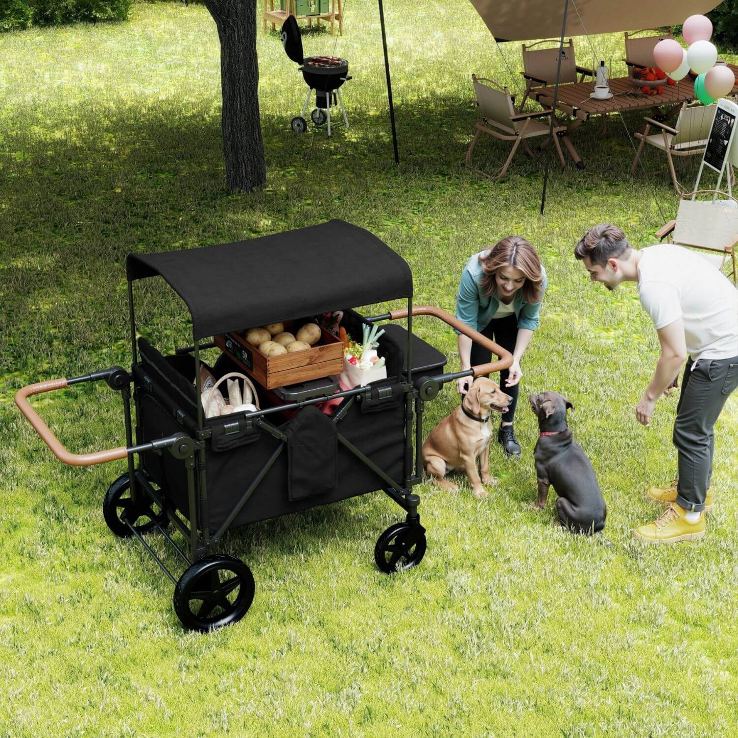 ToyRides Elite Wagon Stroller with 4-Seater - Black is shown outdoors on a grassy lawn, being used by a woman and a man with two dogs