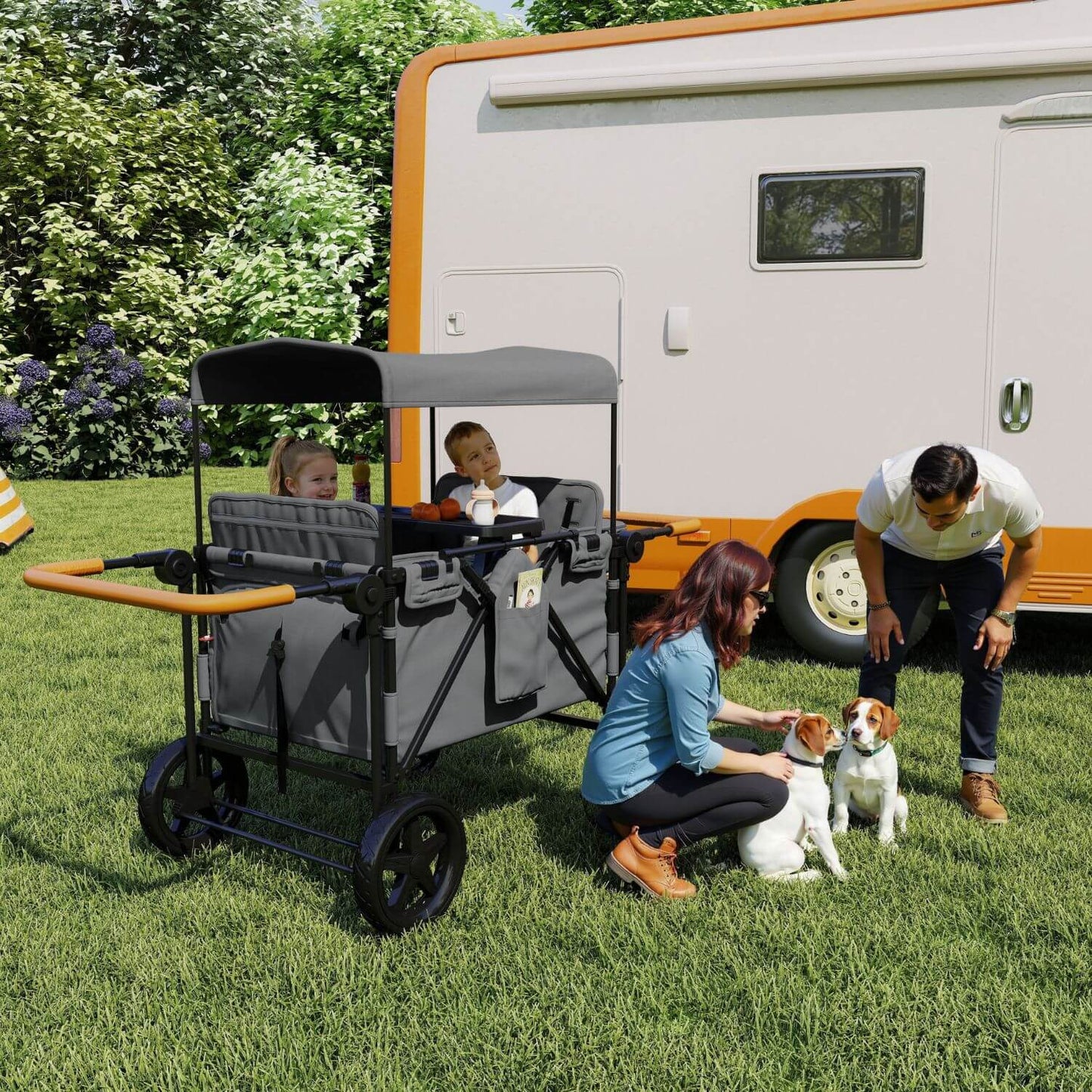 ToyRides Elite Wagon Stroller with 4-Seater - Gray parked on a grassy lawn next to a white and orange camper. Two children are sitting inside the wagon, while a woman and a man are kneeling on the grass next to two dogs.