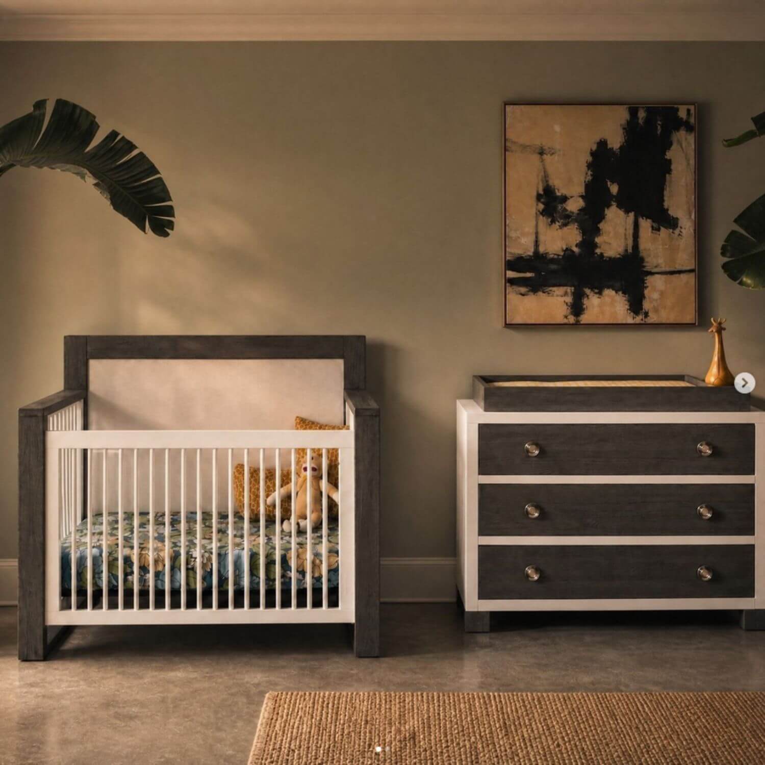 Nursery room with wooden crib and dresser against a beige wall.