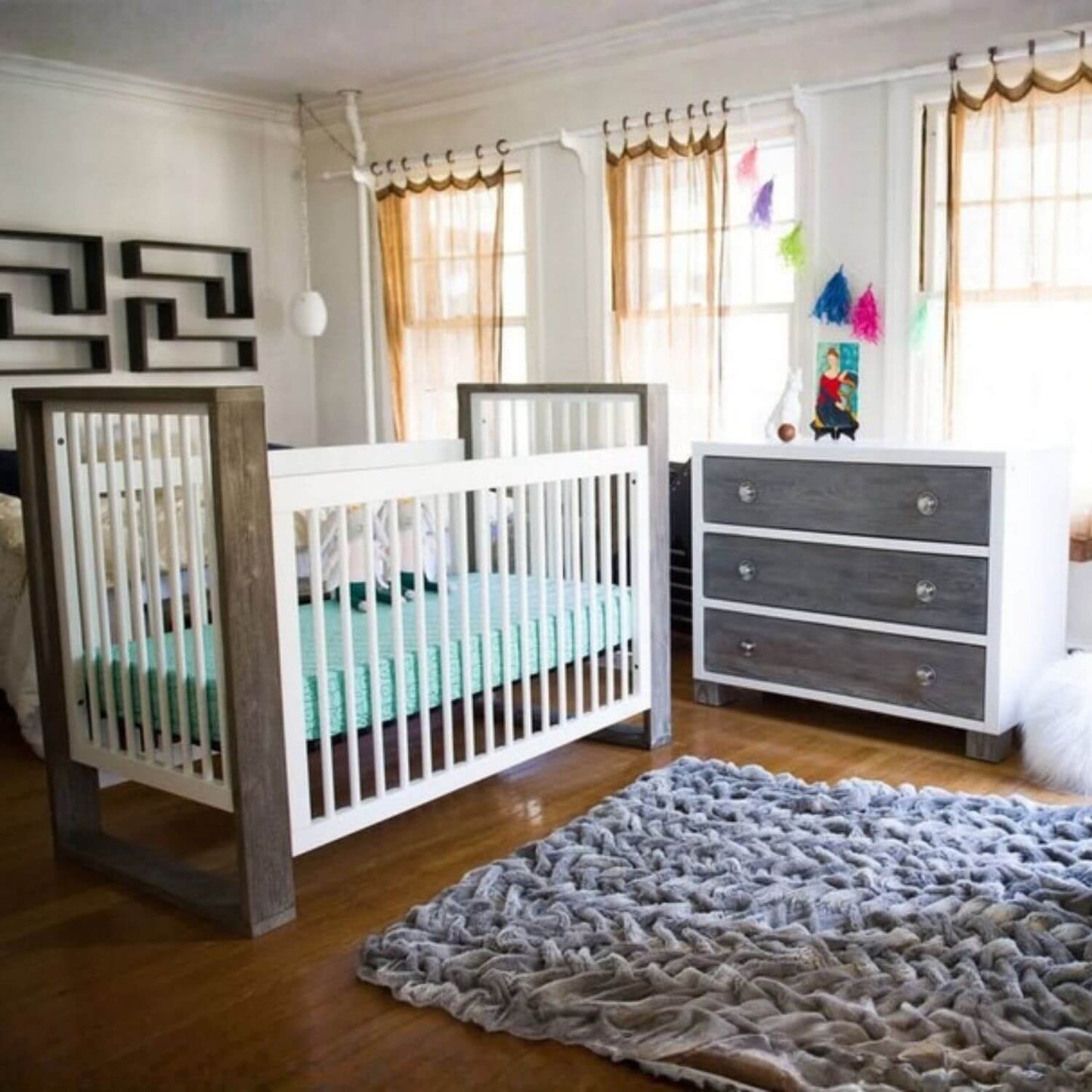 Nursery room with a crib, dresser, and rug.