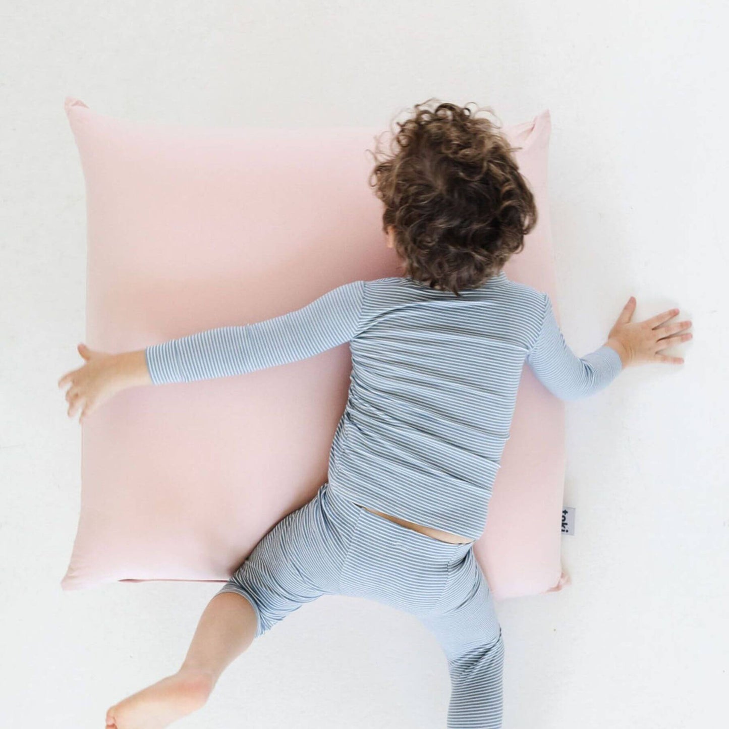 A child lies on their chest on Toki Kids Tutu Bean Bag