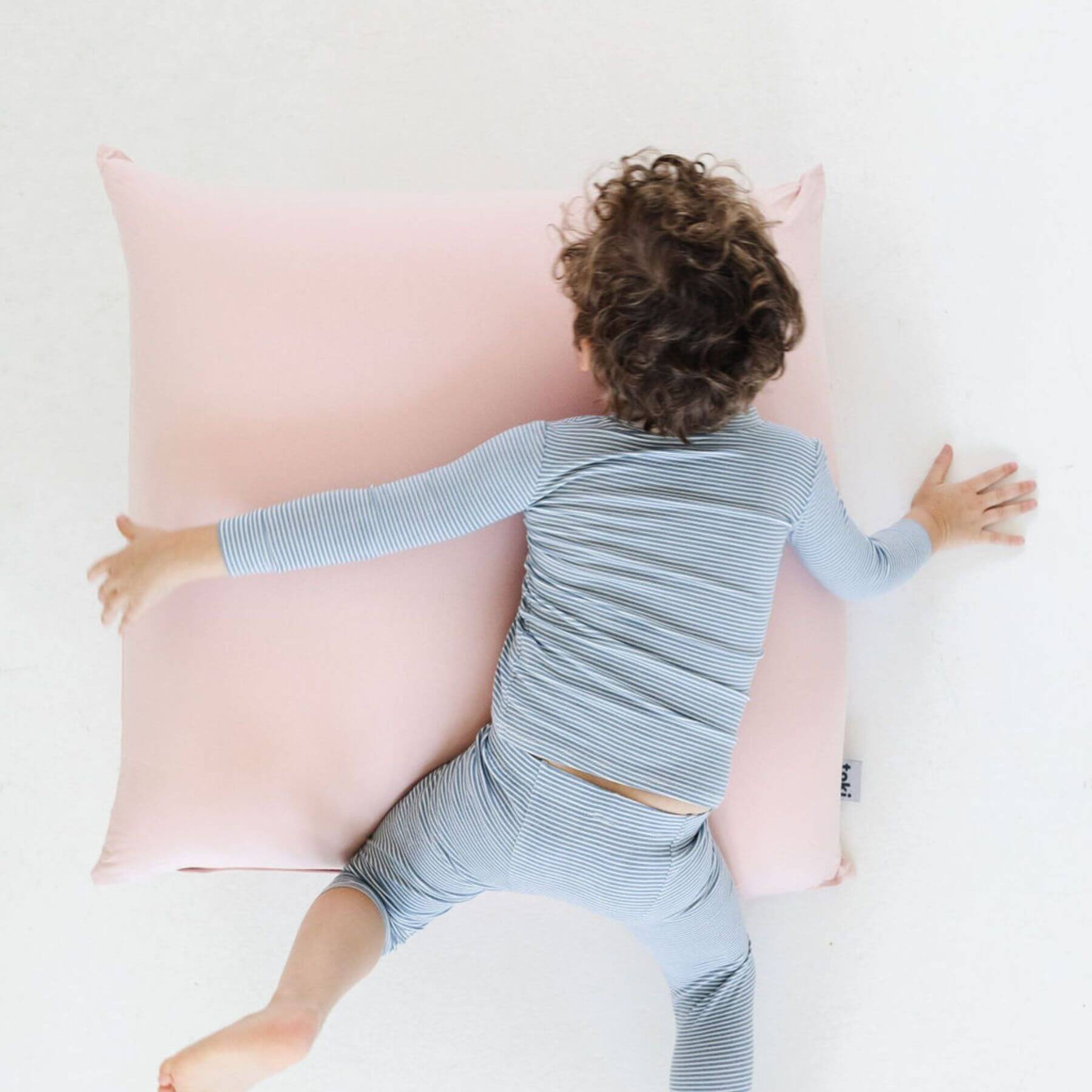 A child lies on their chest on Toki Kids Tutu Bean Bag