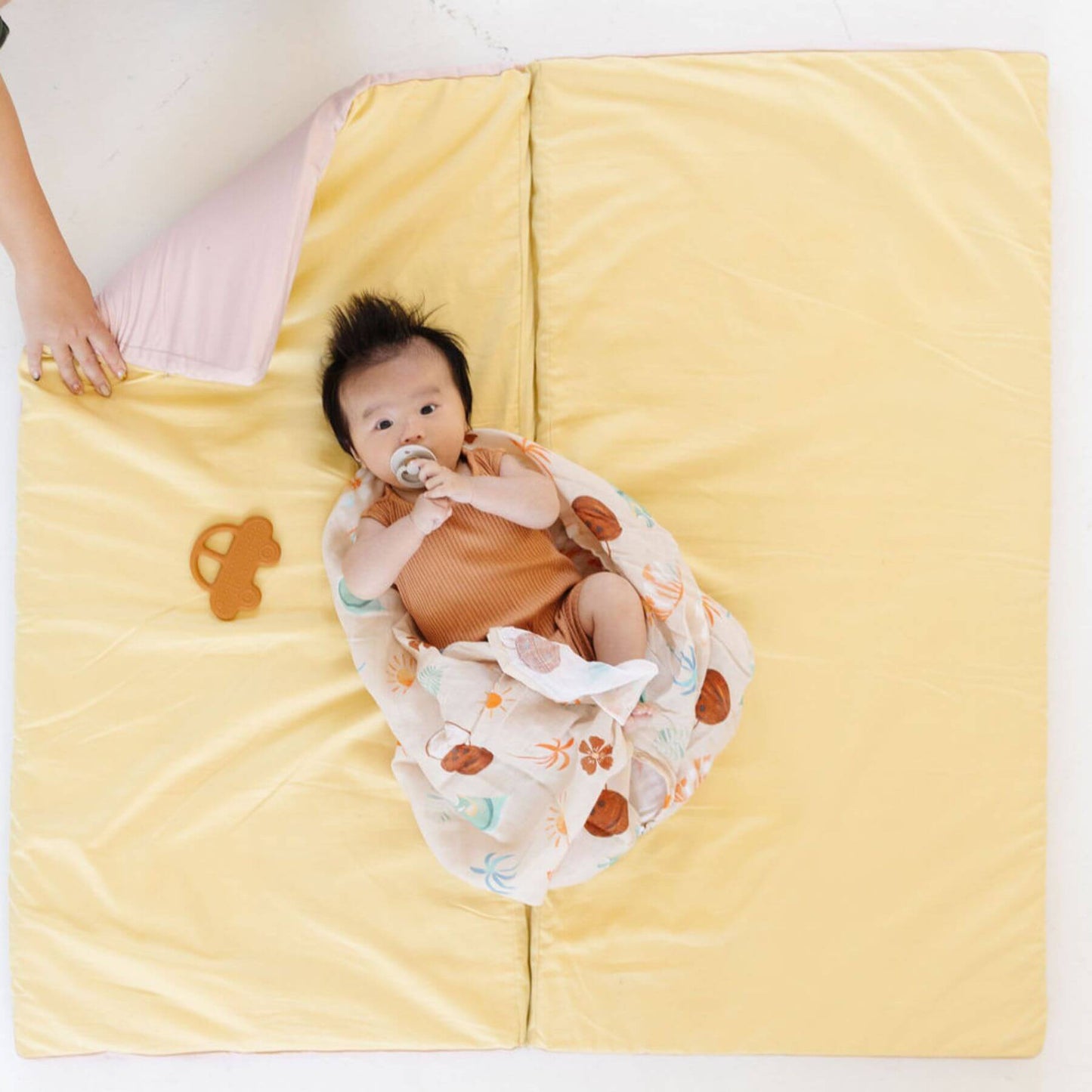 Baby lying on Toki Kids Tutu + Daisy Organic Cotton Mat