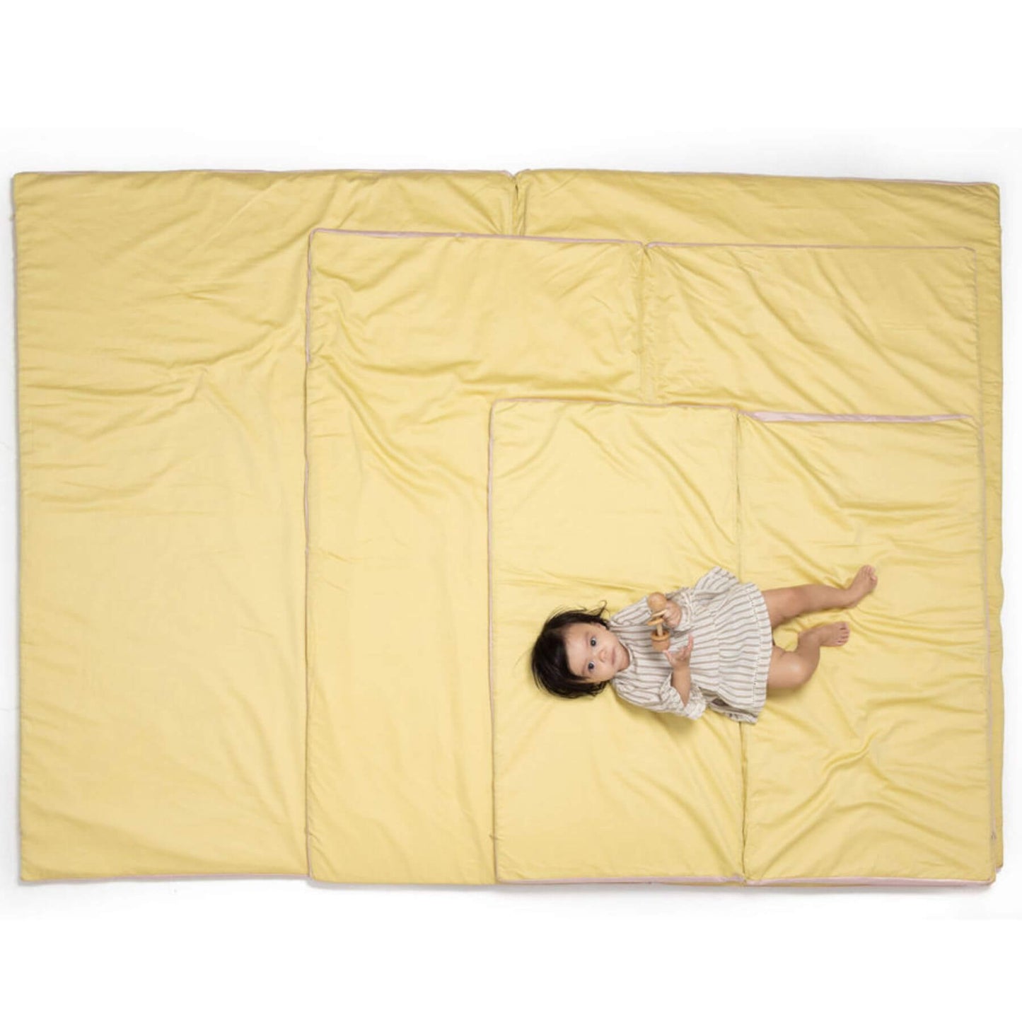 Baby lying on Toki Kids Tutu + Daisy Organic Cotton Mat