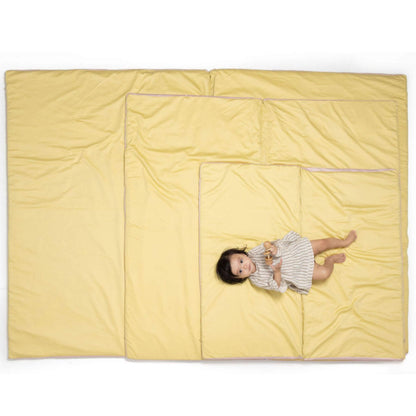 Baby lying on Toki Kids Tutu + Daisy Organic Cotton Mat