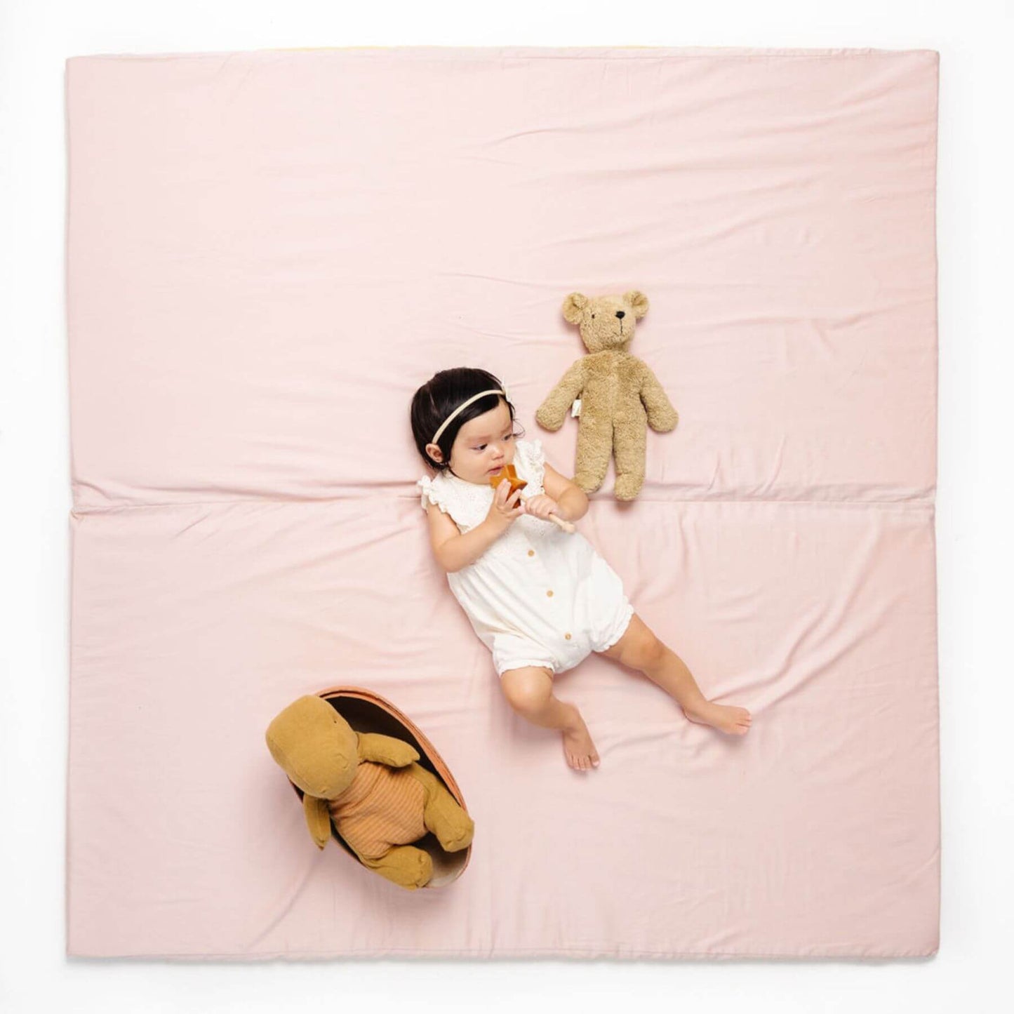 Baby lying on Toki Kids Tutu + Daisy Organic Cotton Mat