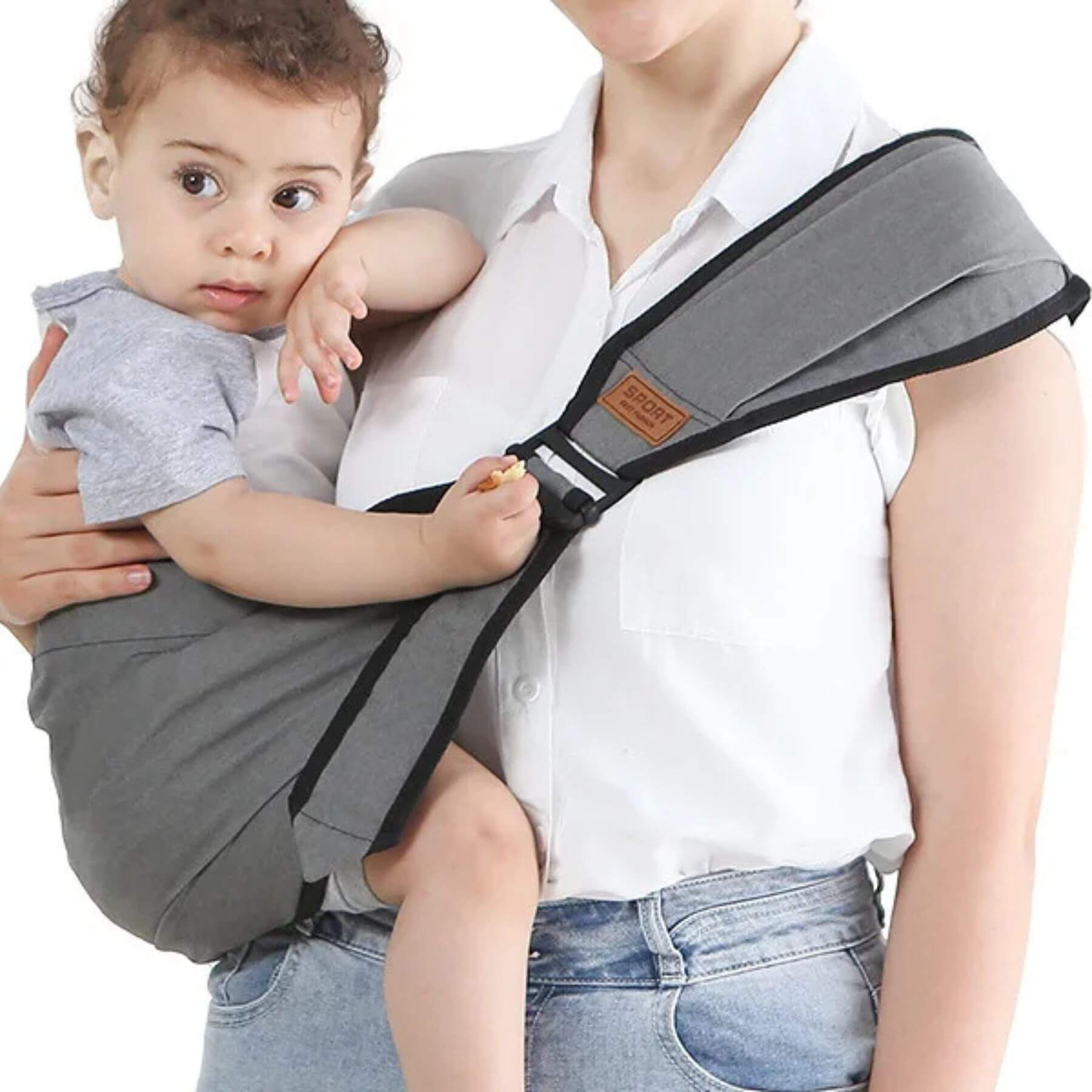 Person holding a baby in RocketBaby USA Universal Baby Carrier Grey with a white shirt and blue jeans.