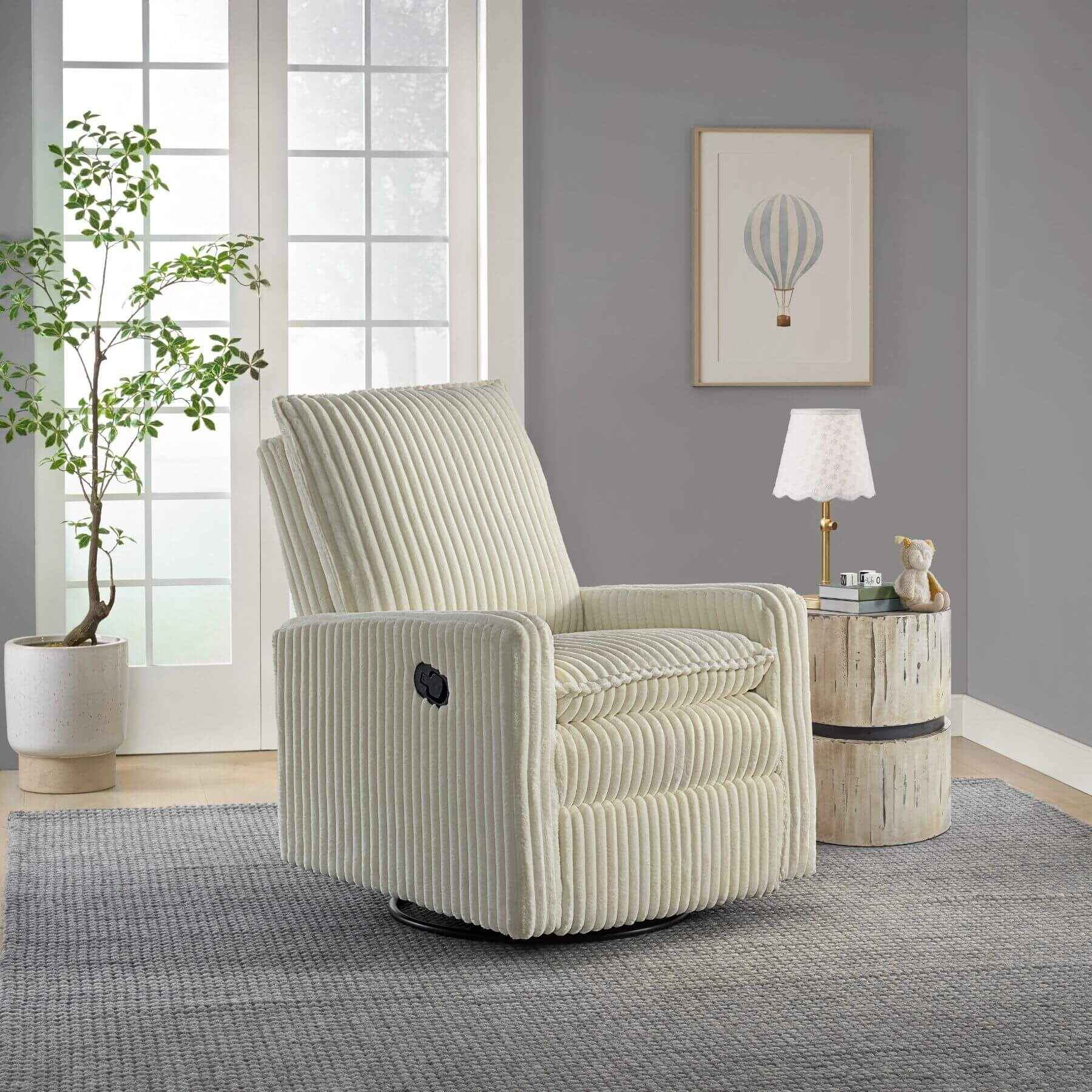 Uptown Nursery Swivel Rocker and Recliner in Corduroy Pearl White in a living room setting with a plant and side table.
