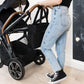 Woman Pulling Stroller, Holding JuJuBe Utility-Strap Tote Diaper Bag Black