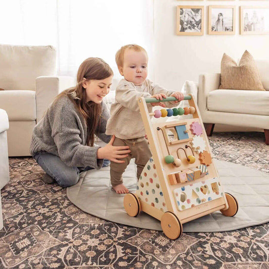 Woman and child playing with Tiny Land® Versatile Natural Wooden Baby Walker in a living room.