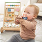 Baby playing with Tiny Land® Versatile Natural Wooden Baby Walker on a bed