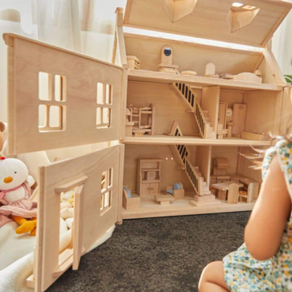 PlanToys Victorian Dollhouse with detailed interior and furniture, child sitting next to it.