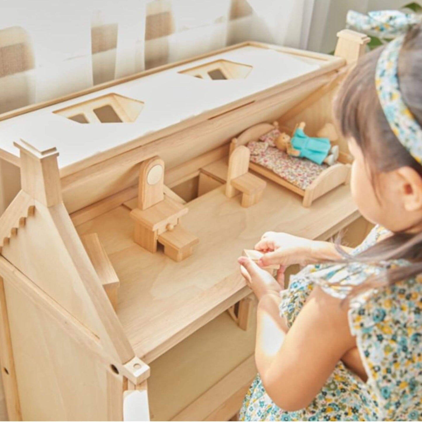 Child playing with PlanToys Victorian Dollhouse