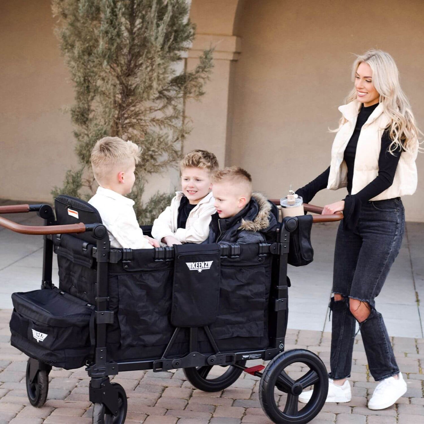 Mom Pushing Kids in Keenz Vyo͞o The Seating Chameleon Stroller Wagon 4-Passengers Black