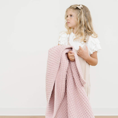 Young girl holding Saranoni Waffle Knit Toddler Blanket - Rosette