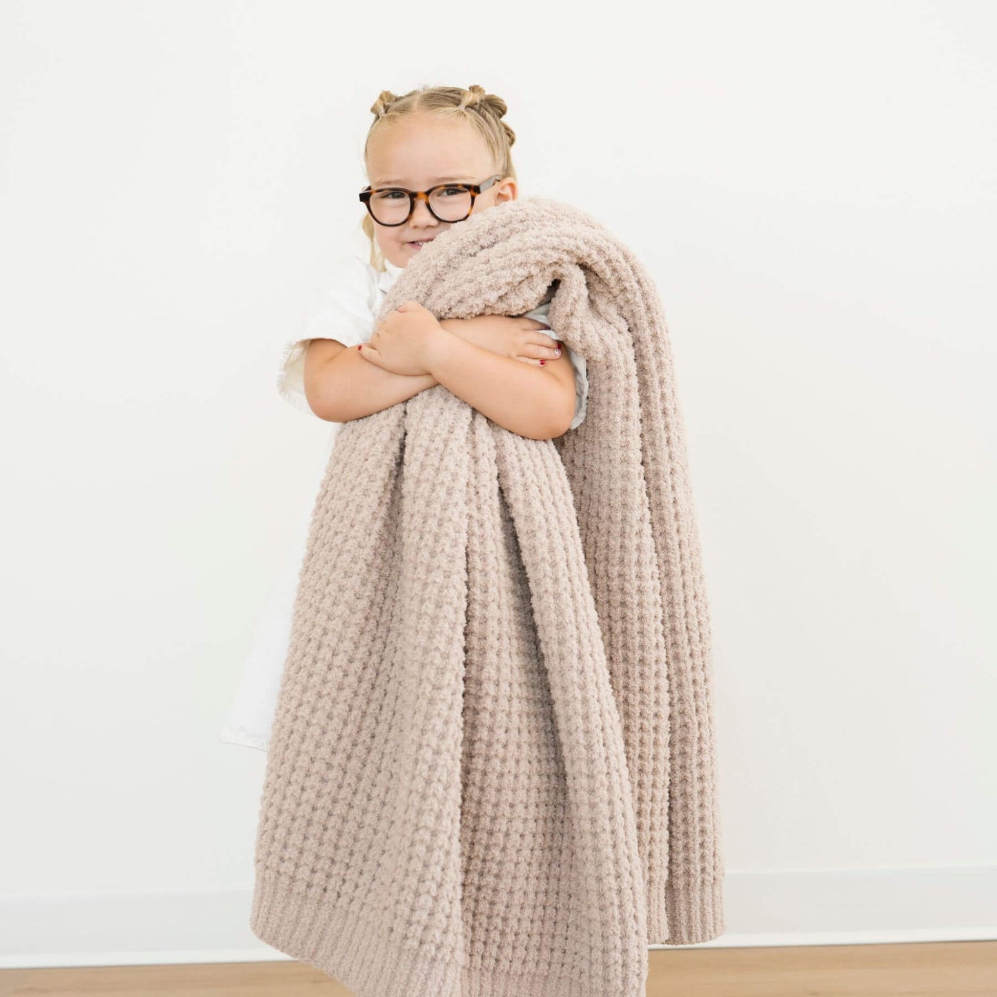 Person wrapped in Saranoni Waffle Knit Toddler Blanket - Wheat
