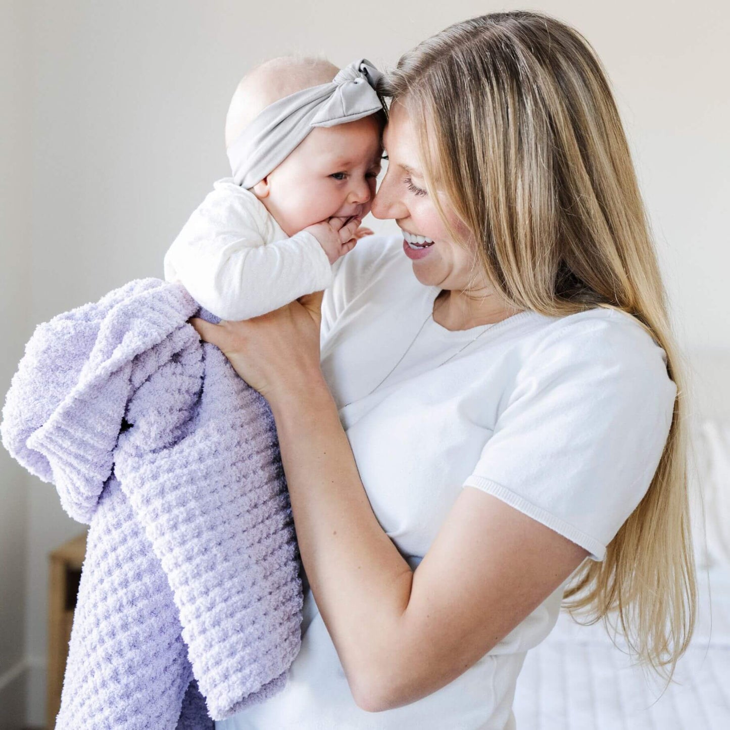 Woman holding a baby and Saranoni Waffle Knit Toddler Blanket - Wisteria in a bright room