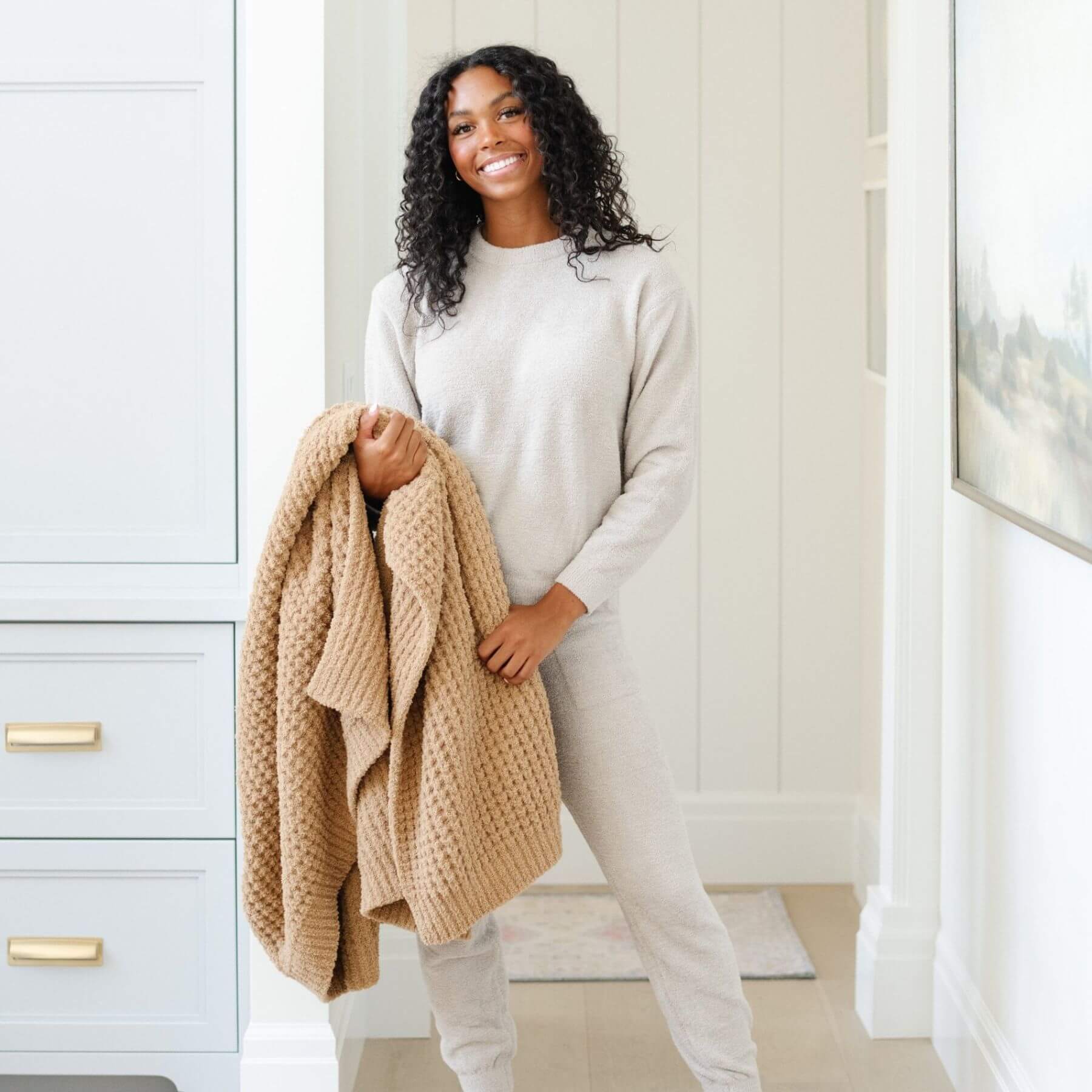 Woman holding Saranoni Waffle Knit XL Throw Blanket - Allspice in a neutral-colored room