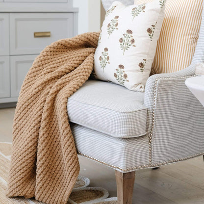 Cozy armchair with Saranoni Waffle Knit XL Throw Blanket - Allspice and patterned pillow in a home setting