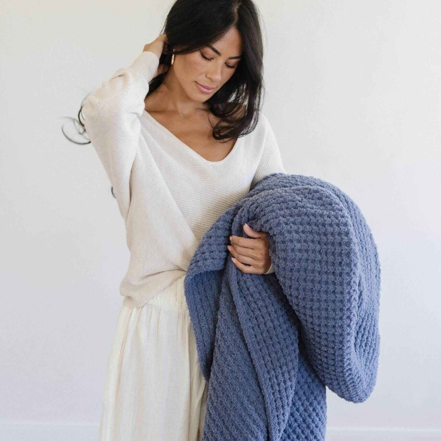 Woman holding Saranoni Waffle Knit XL Throw Blanket - Oxford against a white background