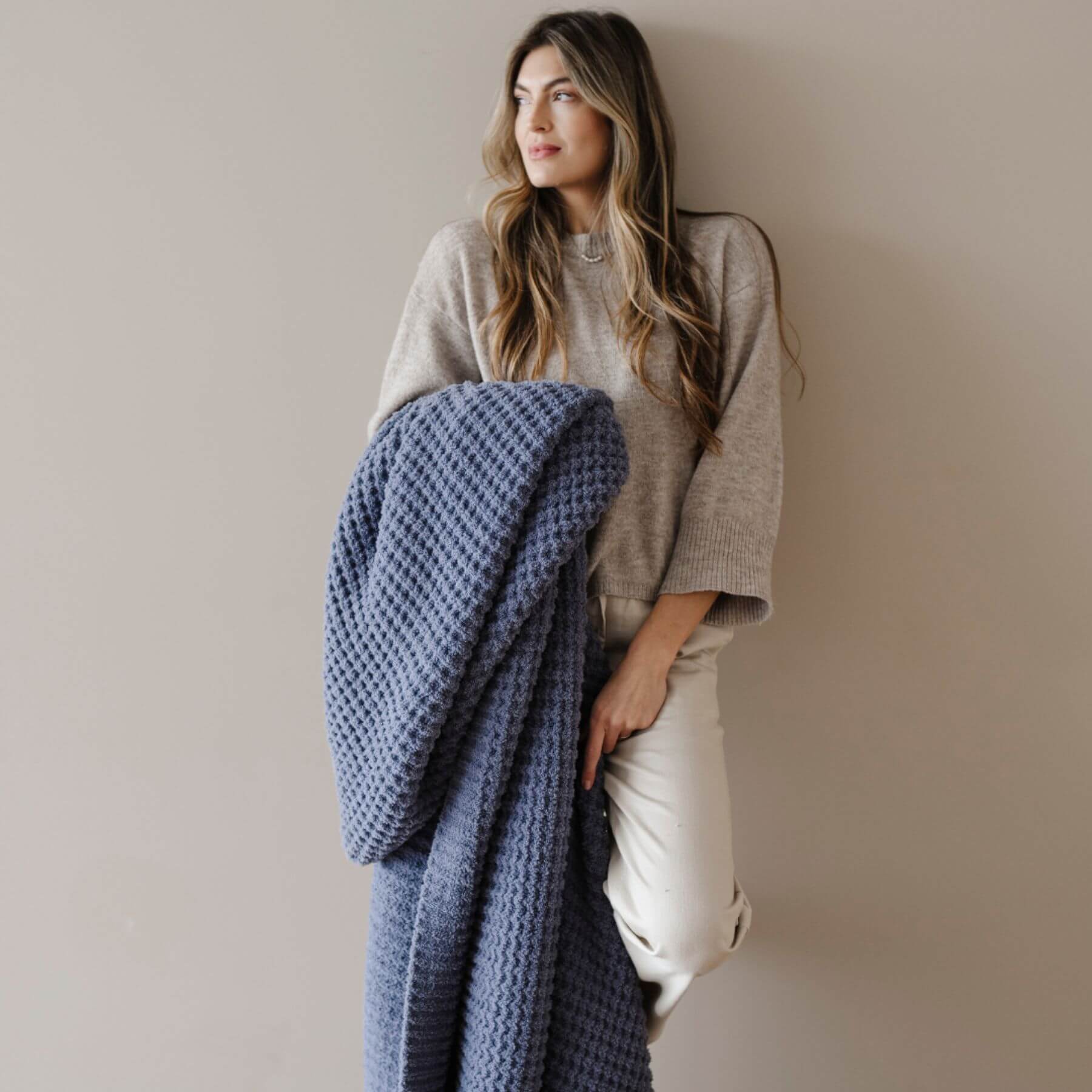 Woman holding Saranoni Waffle Knit XL Throw Blanket - Oxford against a plain background